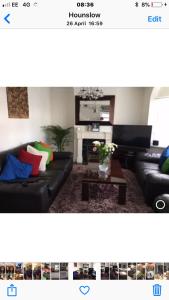 a living room with a black couch and a table at House in Hounslow