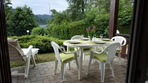 Biały stół i krzesła na patio w obiekcie Les Prairies du lac w mieście Gérardmer