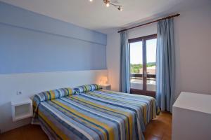 a blue bedroom with a bed and a window at Apartamentos Cristina in Cala Millor