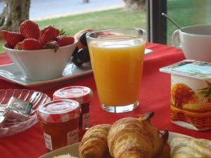 ein Tisch mit einem Teller Gebäck und einem Glas Orangensaft in der Unterkunft Hôtel Anaïade, The Originals City, Saint-Nazaire Pornichet in Saint-Nazaire