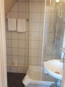 ein Bad mit einer Dusche und einem Waschbecken in der Unterkunft Hotel Panorama Garni in Helgoland
