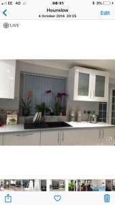 a picture of a kitchen with white cabinets at House in Hounslow