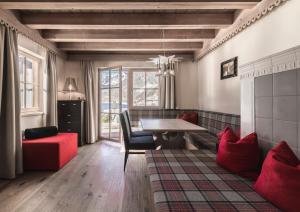 a living room with a table and a red couch at Hotel & Chalets Edelweiss in Madonna