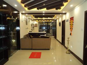 an office lobby with a couch and a desk at Mani's residency in Madurai