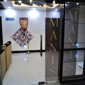 uma porta de vidro com um sinal na parede em Mani's residency em Madurai
