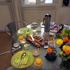 a table with plates of food on top of it at Chambres d'hôtes La Maison Hippolyte in Paris