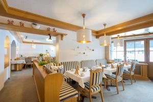 ein Restaurant mit Tischen, Stühlen und Fenstern in der Unterkunft Hotel garni Gerberhof ***S in Oberstdorf