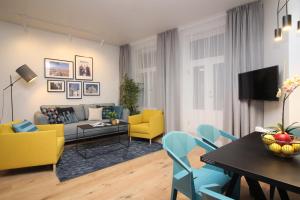 un salon avec des chaises jaunes et bleues et une table dans l'établissement Tallinn City Apartments Old Town Suites, à Tallinn