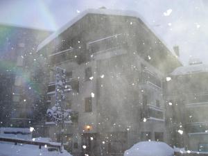 una tormenta de nieve frente a un edificio en Hotel Al Caminetto en Valtournenche