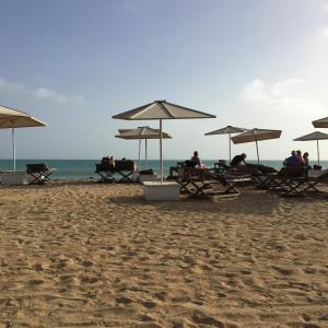 a group of people sitting under umbrellas on a beach at Santa Maria flats in Santa Maria