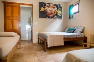 a room with a bed and a couch and a painting at Casa Bougainvilla in Jericoacoara