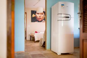 - un réfrigérateur blanc dans le couloir orné d'une peinture dans l'établissement Casa Bougainvilla, à Jericoacoara