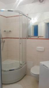 ein Badezimmer mit einer Dusche, einer Badewanne und einem WC in der Unterkunft Apartament Rezydencja Bursztyn in Świnoujście