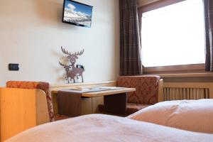 a room with a table and a deer on the wall at Hotel Champagne in Livigno