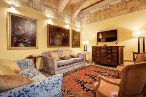 a living room with a couch and a tv at Palazzo Paolina Boutique Hotel in Valletta