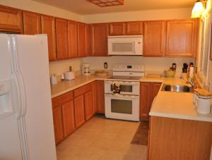 eine Küche mit Holzschränken und weißen Geräten in der Unterkunft Bear Bluff in Rileyville