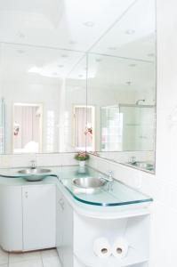 a bathroom with two sinks and a large mirror at Hotel Milenio in Ponte Nova