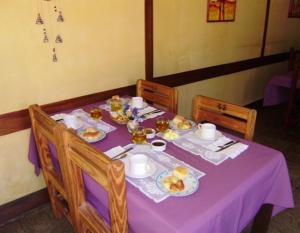 a purple table with plates of food on it at Hostería Las Gemelas in Capilla del Monte