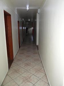 a hallway with a tile floor and a long corridor at Hotel Transbrasil in Belém