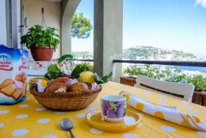 un tavolo con un cesto di pane e una tazza di caffè di ISCHIA - PANORAMIC APARTMENT ON THE SEA a Ischia