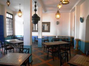 a dining room with tables and chairs and lights at Hôtel Central in Casablanca