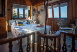 a bedroom with a bed and a chair and windows at La Casa Del Doganiere in Monterosso al Mare +33 photos