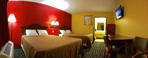 een hotelkamer met 2 bedden en een bureau bij Relax Inn McRae in McRae