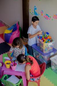 un uomo e due bambine che giocano con i giocattoli di Pousada Chalés do Julião a Ubatuba