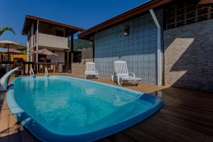 una grande piscina blu su una terrazza con due sedie di Pousada Chalés do Julião a Ubatuba Altre 32 foto