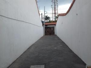 カボ・フリオにあるCantinho aconchegante 2 quartos, com ar condicionadoの白い壁と門のある路地