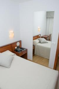 a hotel room with two beds and a mirror at Hotel Brisa in A Coruña