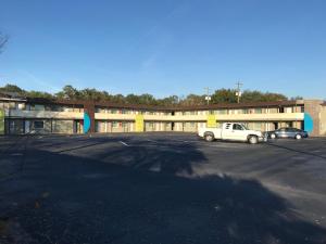 un estacionamiento con un camión blanco estacionado frente a un edificio en Oasis Inn, en Beaufort