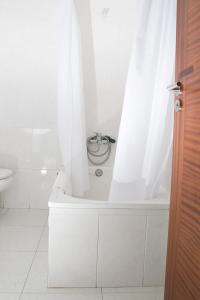 a white bathroom with a tub with a shower curtain at Hotel Brisa in A Coruña +32 photos