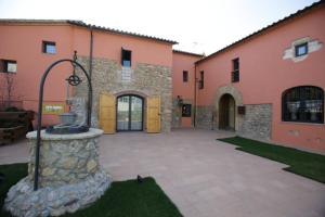 a building with a fountain in the middle of a courtyard at Hotel Can Panyella in Gélida