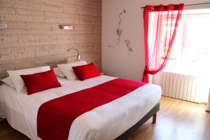a red and white bed in a room with a window at Logis Hôtel "Ici m'aime" in Rouvray
