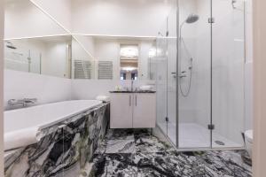 a bathroom with a tub and a shower and a sink at Parkview Boutique Apartments in Vienna