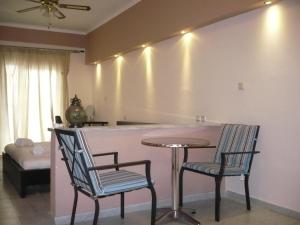 una cocina con una barra con 2 sillas y una mesa en Alexandros Hotel en Leptokarya