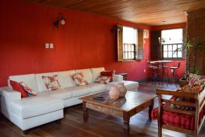 a living room with a white couch and a table at Pousada Bela Cigana in Conservatória