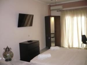 um quarto com uma cama e uma televisão na parede em Alexandros Hotel em Leptokarya