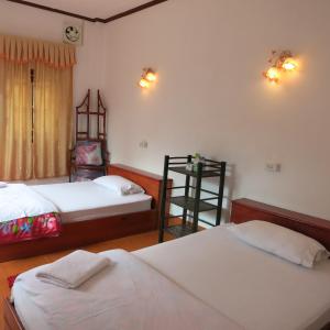 a bedroom with two beds and a shelf in it at Kongkeo Guesthouse in Muang Phônsavan