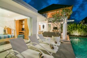 a villa with a swimming pool and a living room at Villa Kobe Beachside Berawa Canggu location in Canggu