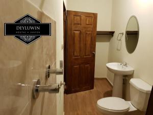 a bathroom with a toilet and a sink at Hostal DEYLUWIN in Juayúa