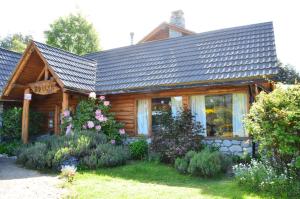 a log cabin with flowers in front of it at Hosteria Epulen in Villa La Angostura