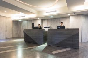 two people sitting at a desk in an office at Tomorrow Hotel in Taipei