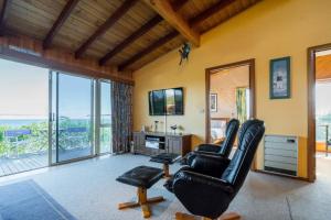 een woonkamer met 2 stoelen en een televisie bij Freycinet Panorama in Coles Bay