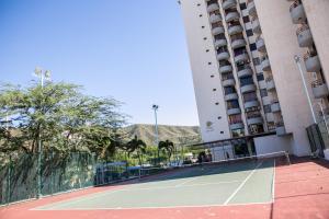 una pista de tenis frente a un edificio en Apartamento Moderno con Piscina Rodadero, en Santa Marta