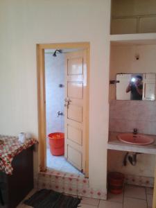 a person taking a picture of a bathroom with a sink at St. Antonys Lodge in Cochin