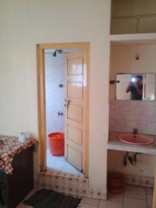 a person taking a picture of a bathroom with a sink at St. Antonys Lodge in Cochin