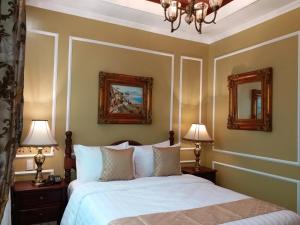 大雅台的住宿－Lee Boutique Hotel Tagaytay，一间卧室配有一张带两盏灯和两面镜子的床。