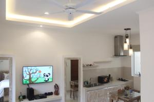 a living room with a flat screen tv on the wall at Green Studio Apartment Seminyak in Seminyak
